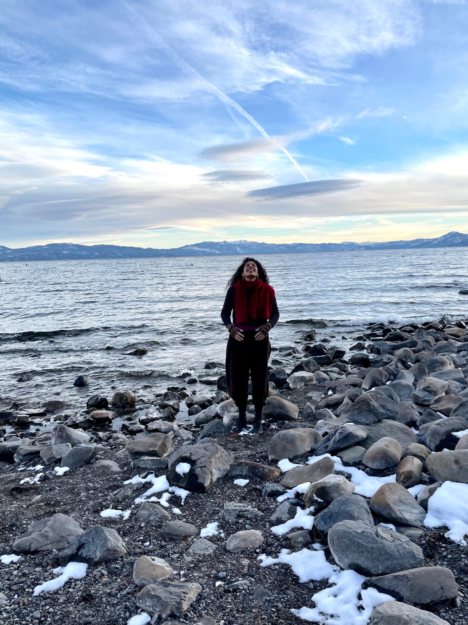 Armineh Turgeon at the lake shore, face lifted to the sky, hands on her belly in breath