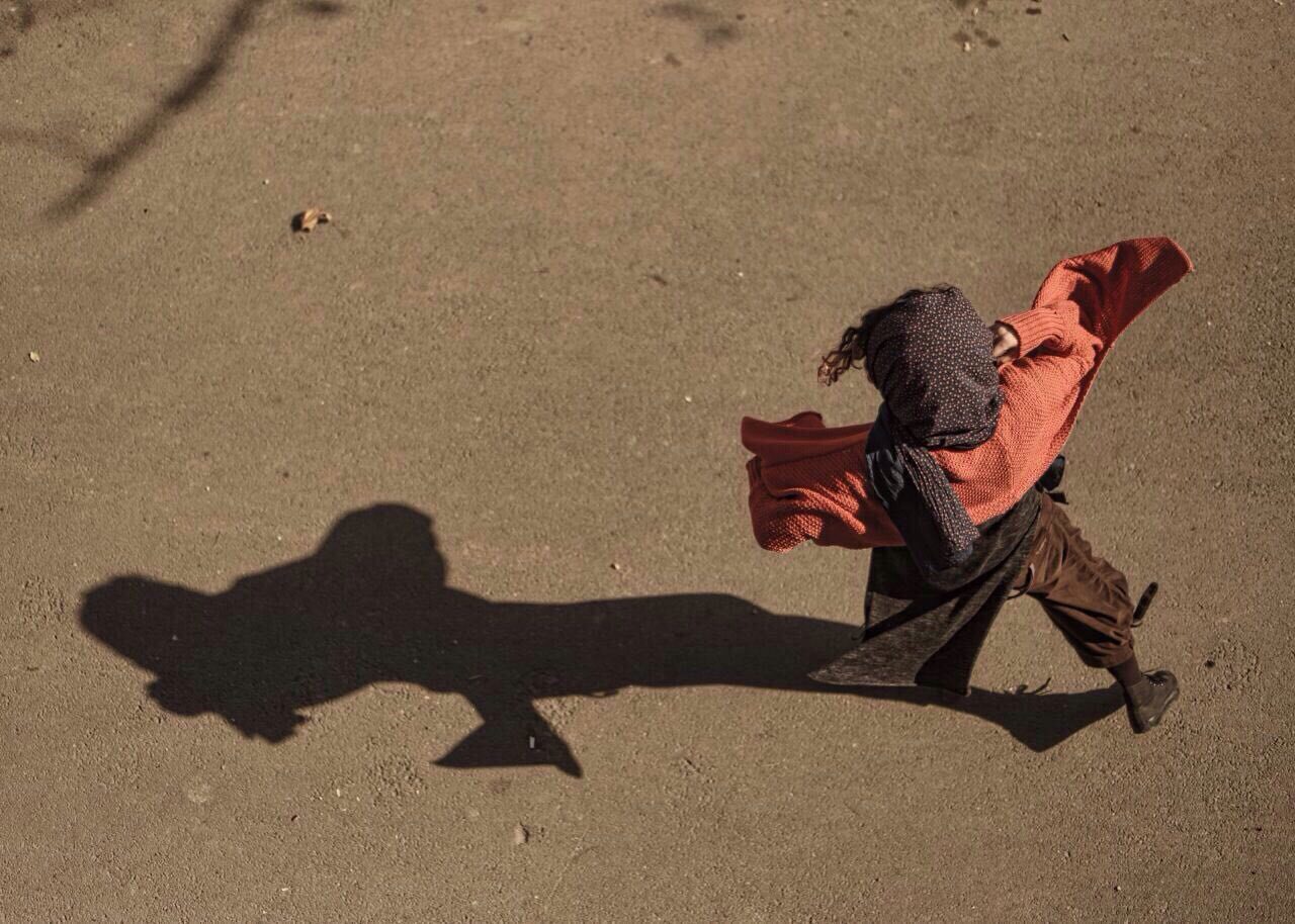 Seen from above, Armineh Turgeon dancing freely across open ground, her long shadow stretching behind her
