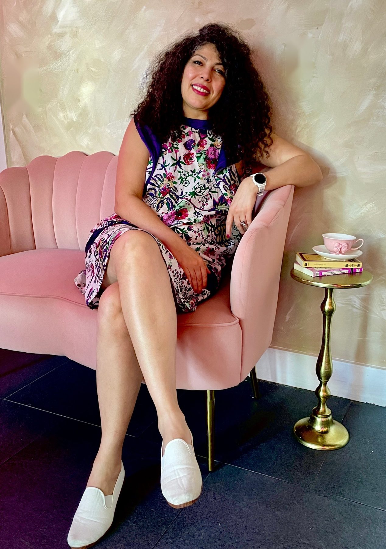 Armineh smiling, seated in a blush velvet chair